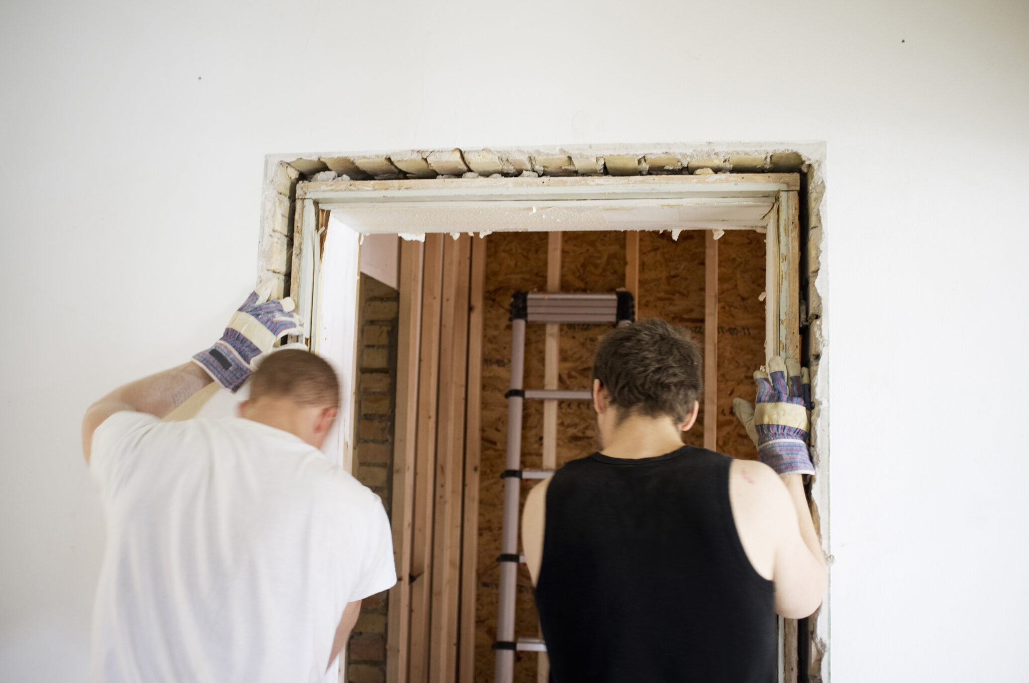 Rear view of carpenters working on door frame